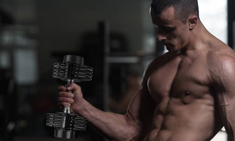 Bodybuilder Exercising Biceps With Dumbbells