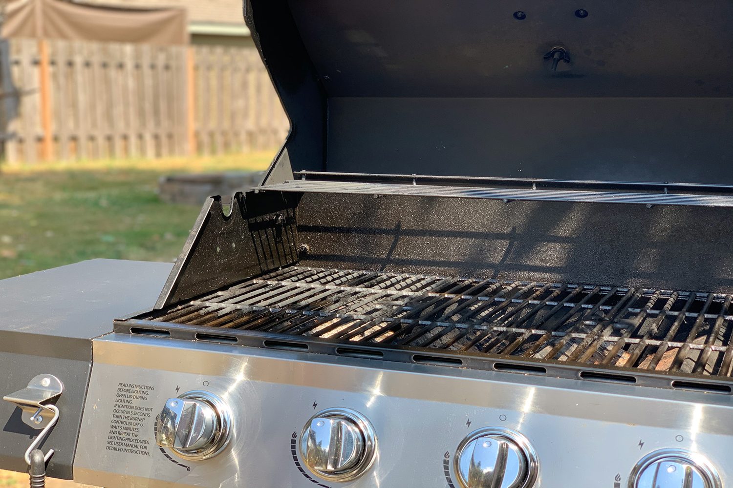 A dirty gas grill is primed for cleaning.