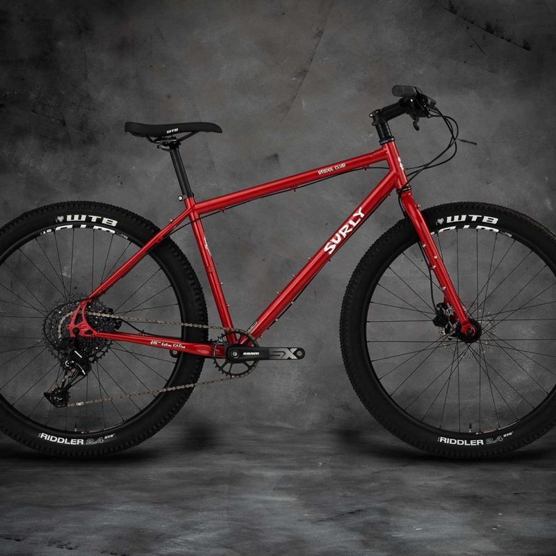 Surly Bridge Club All Road Touring Bike in red on a dark studio background.