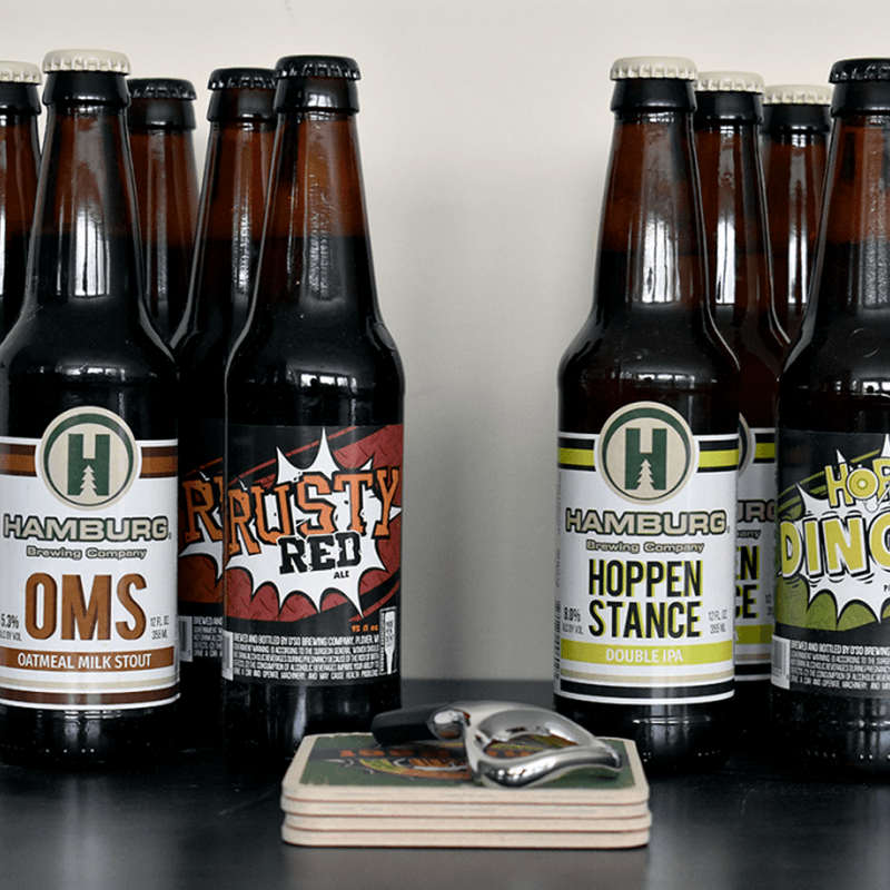 Assorted bottles of beer, coasters, and a can opener from The Original Craft Beer Club.