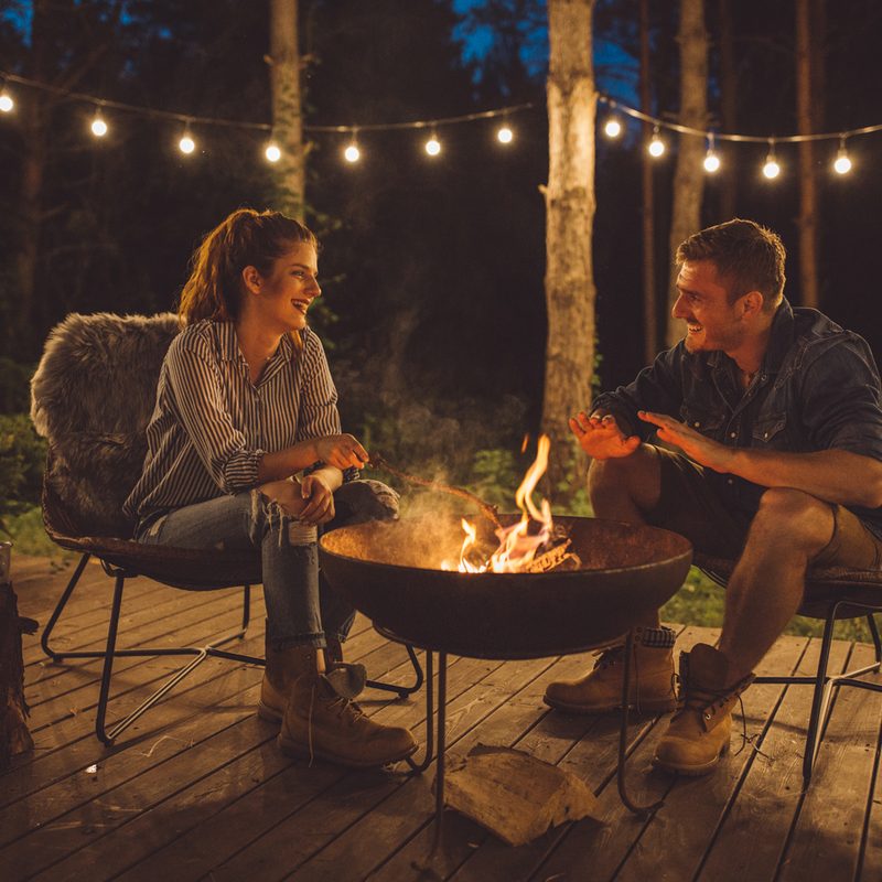 A couple talking on the porch at night