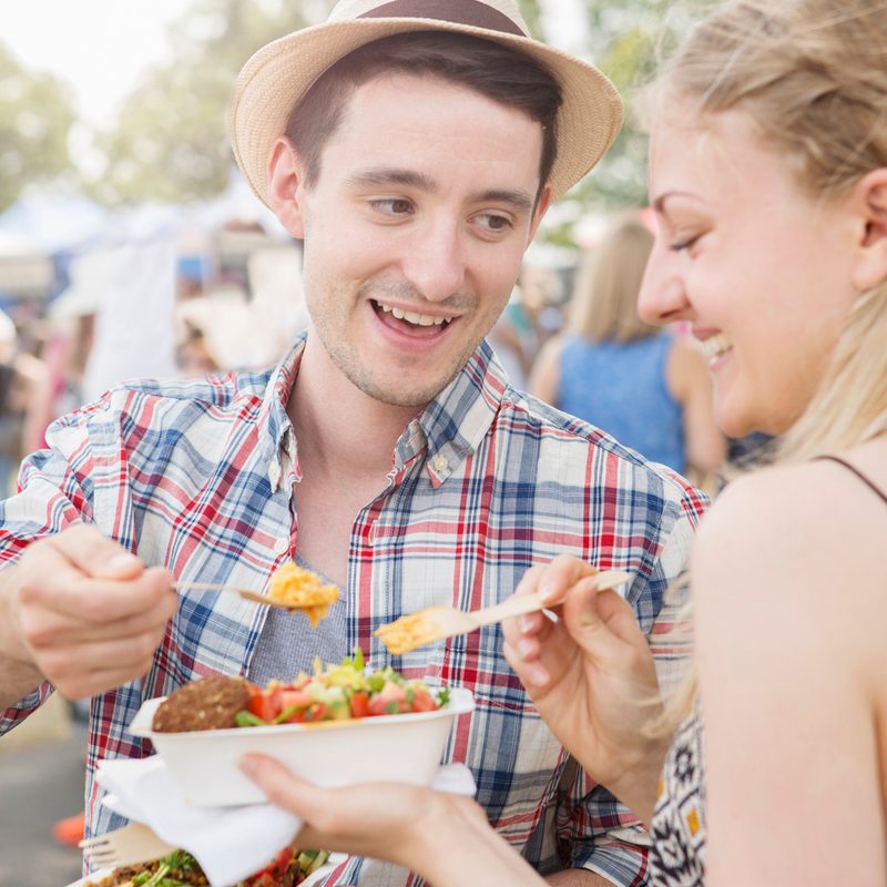 A couple sharing the lunch they bought at the food festival.