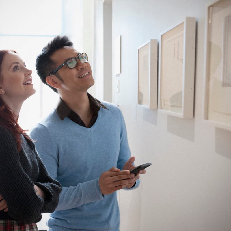 A couple admiring artwork in an art gallery.