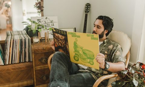 A man reading a vinyl album inside Magnolia store