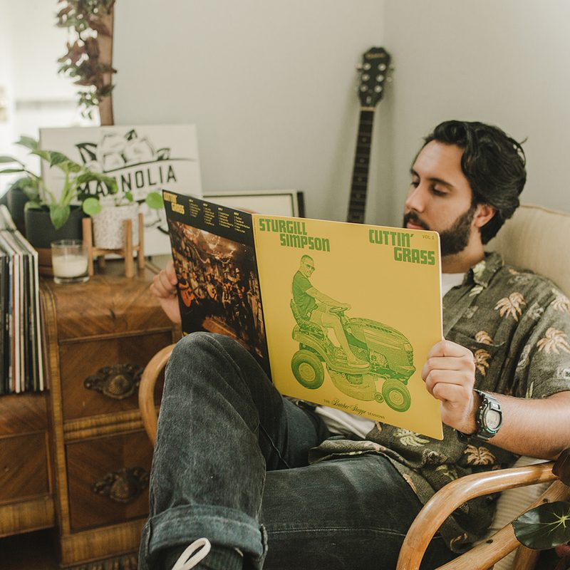 A man reading a vinyl album inside Magnolia store