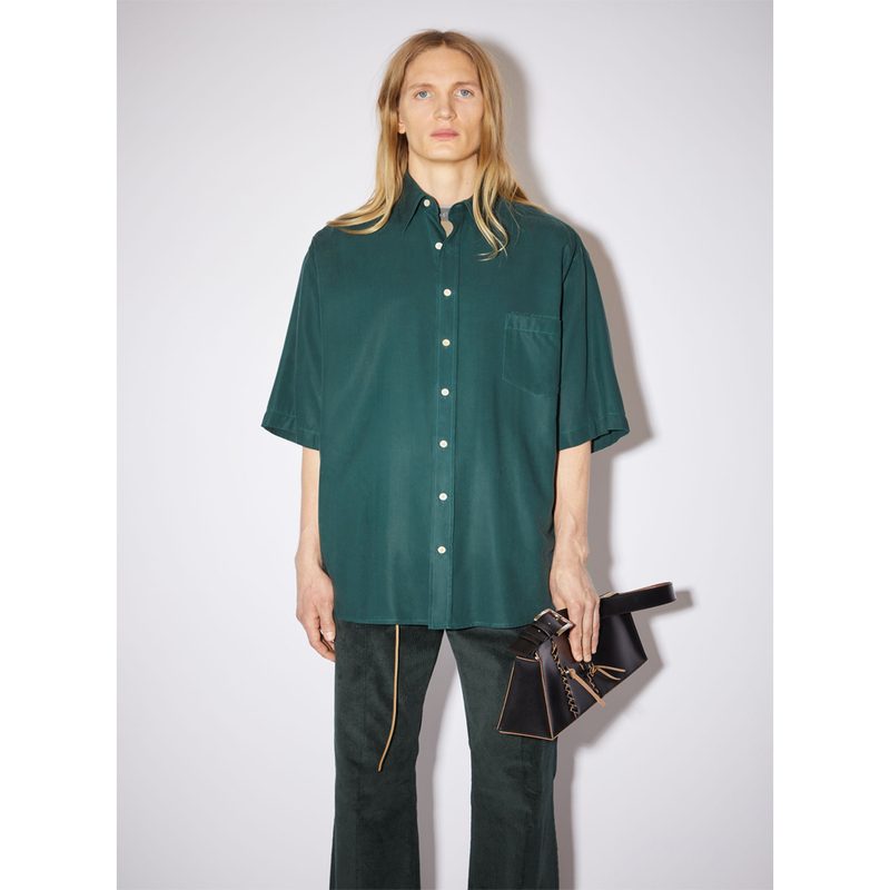 A man wearing a green oversized shirt from Acne.