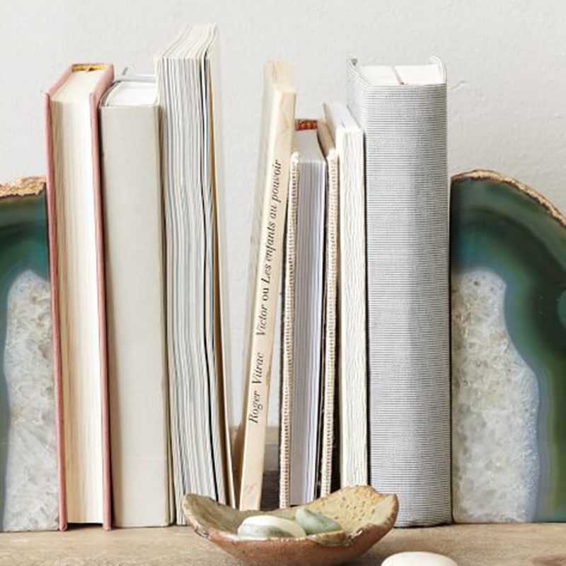 Green agate bookends on book sides with decorative pebbles in front.