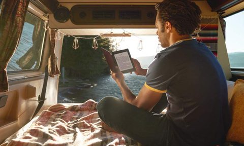 Man using the Amazon kindle paperwhite ereader inside of van