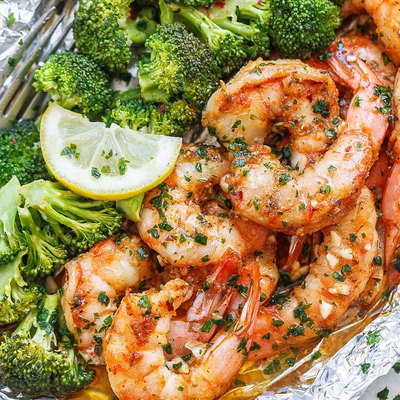 Baked shrimp and broccoli with garlic lemon butter sauce packed in foil.