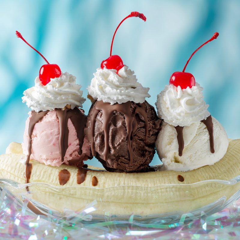 Tropical Banana Split with cherries and whip cream on top.
