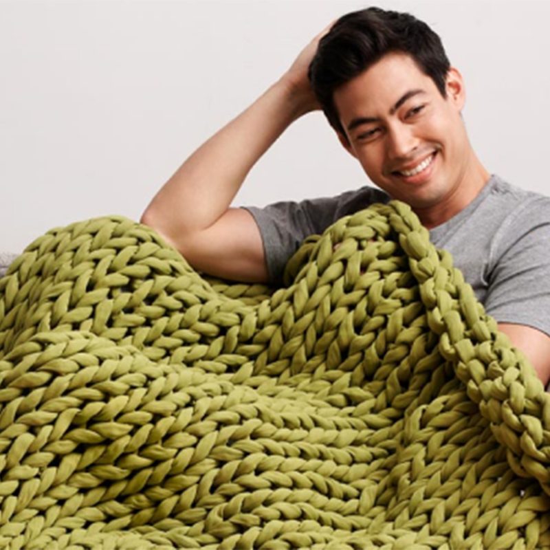 Eucalyptus green Bearby weighted blanket on man on couch.