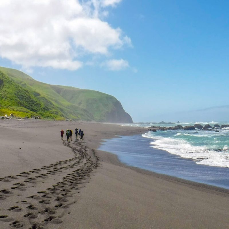 Adventurers leaving footprints on the sand along the shores of California&rsquo;s Lost Coast.