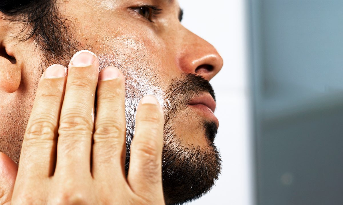Man putting product on his face and beard.