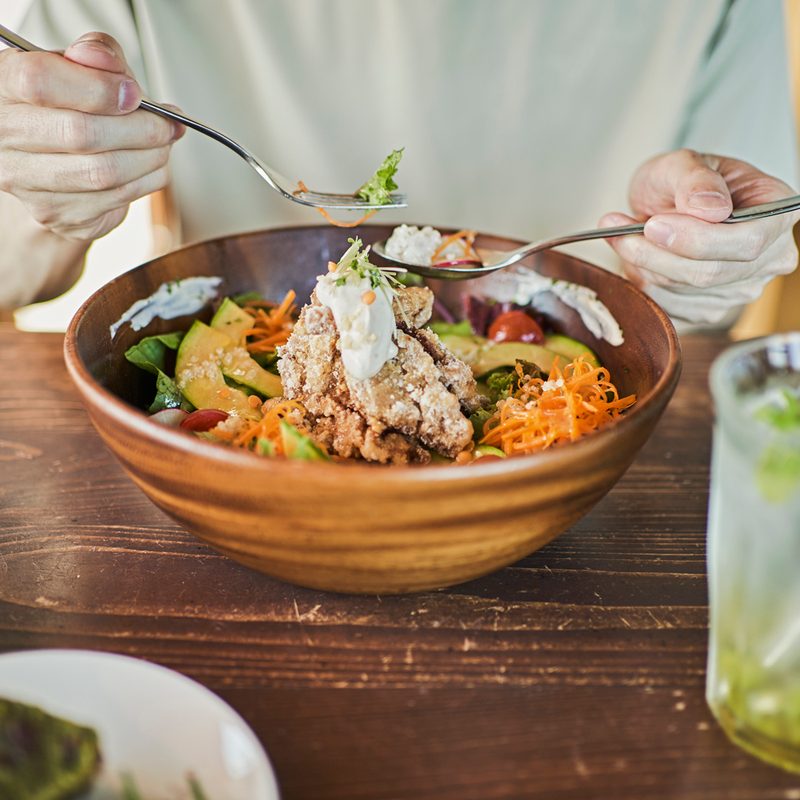 A man eating a hearty lunch from a bowl.