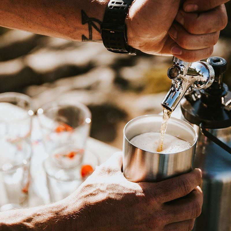 Man pouring a draft beer from a pressurized beer growler.