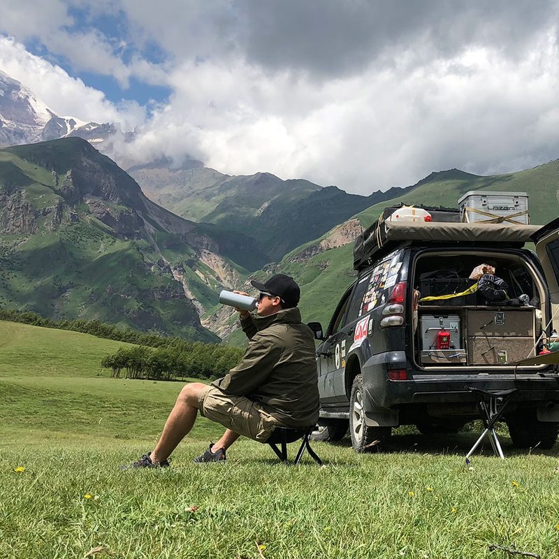 Man relaxing in the mountains with the best camping stool.