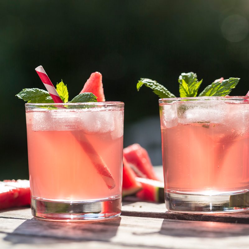 Two thirst-quenching glasses of watermelon cocktails on a wooden table.