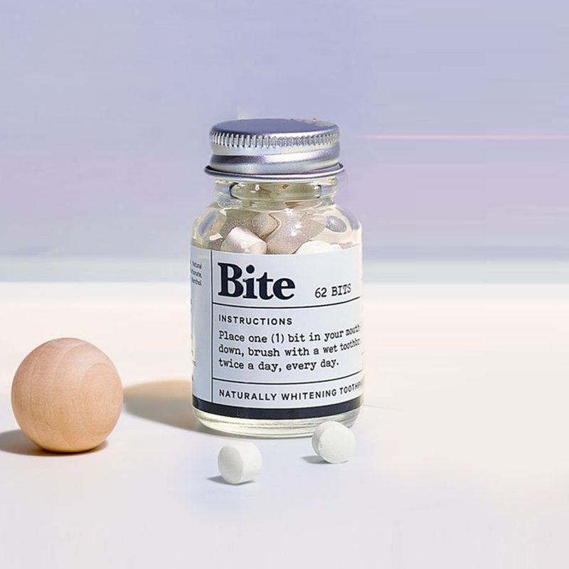 Jar of Bite toothpaste bits on purple background.