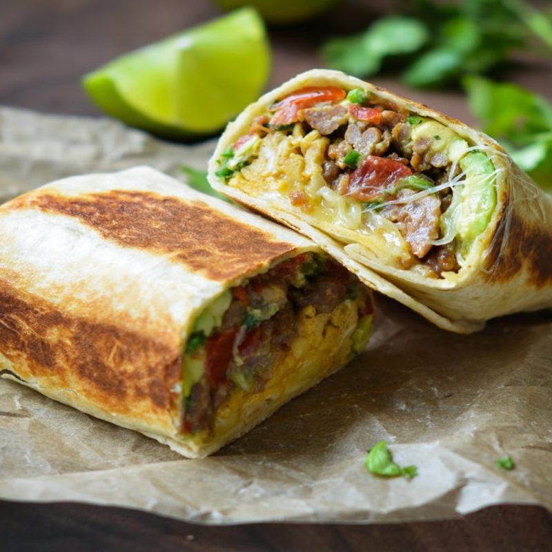 Sliced breakfast burritos on absorbing paper.