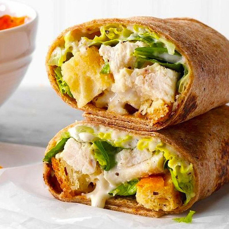 Two Chicken Caesar Wraps on absorbing paper.