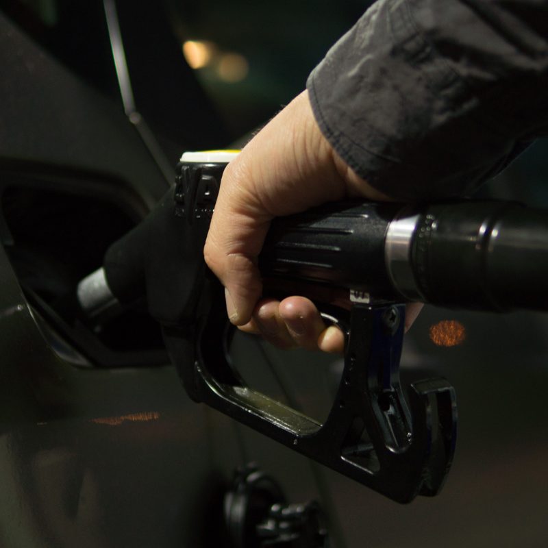 Someone filling up their gas tank with fuel rewards app.
