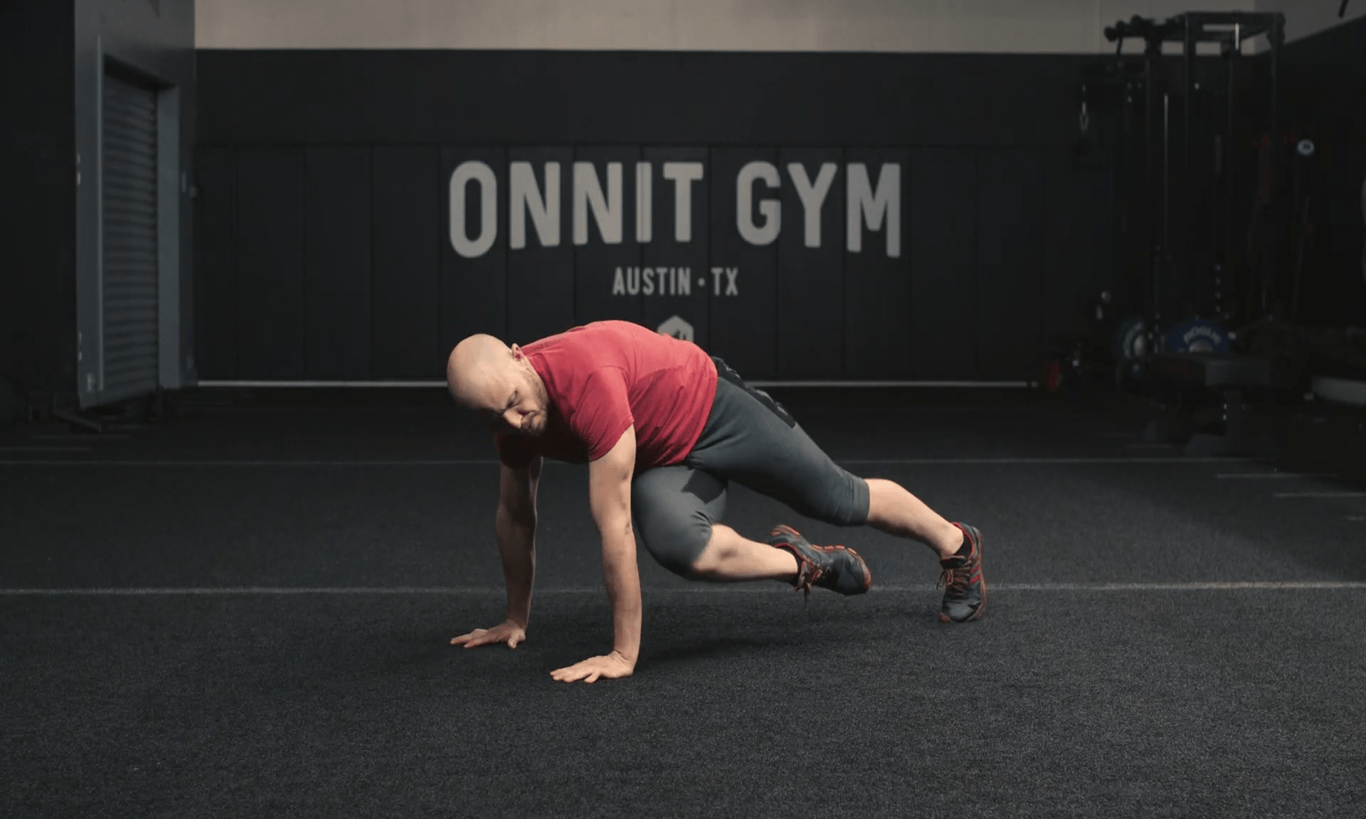 An athlete performing the crossover mountain climbers at the Onnit Gym.