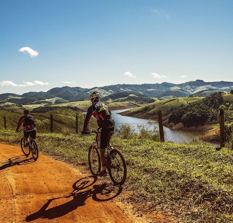 Two men cycling on a dirt road
