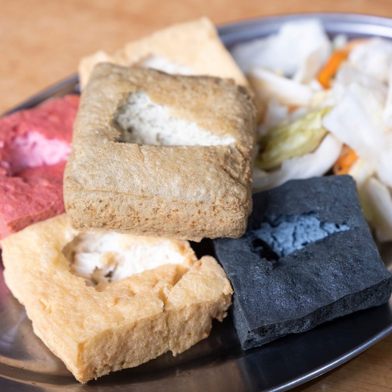 Stinky tofu, a Chinese fermented tofu, served on an oval plate.