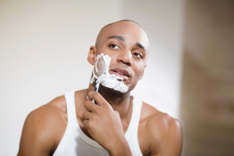 Man shaving his face with safety razor