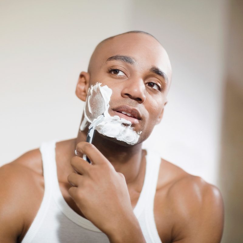African man shaving face.