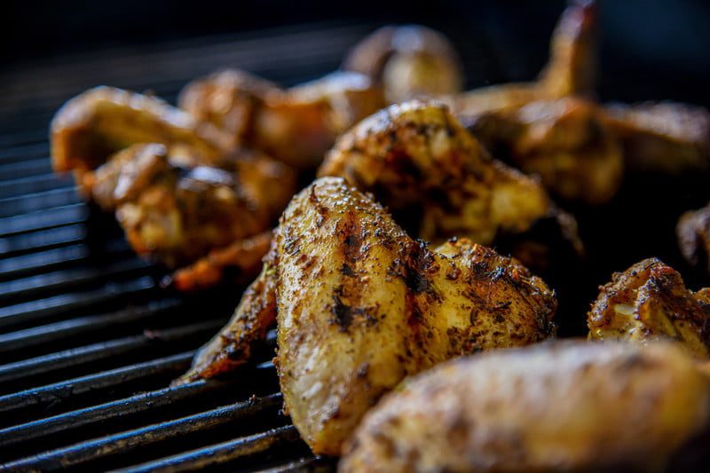 Barbecued cornell chicken on a grill grate.