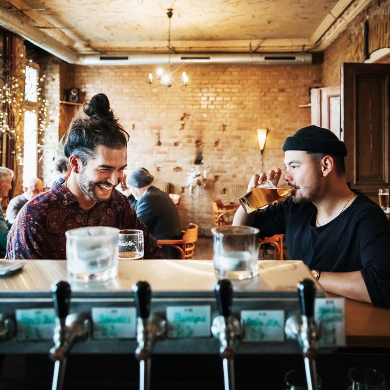 Two men enjoying drinks in a bar.