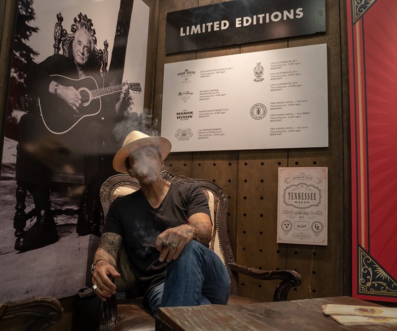 Jon Huber in his Crowned Head office, smoking a cigar