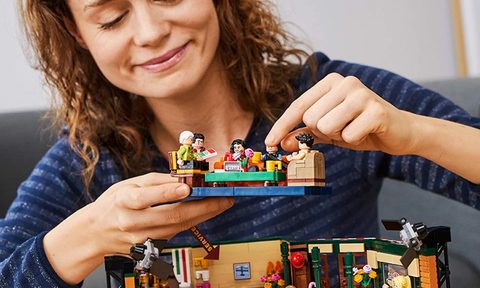 Person assembling a LEGO Ideas 21319 Central Perk Building kit.
