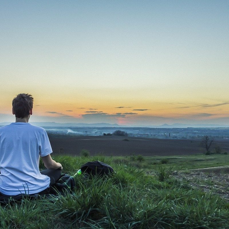 Person meditating in a field