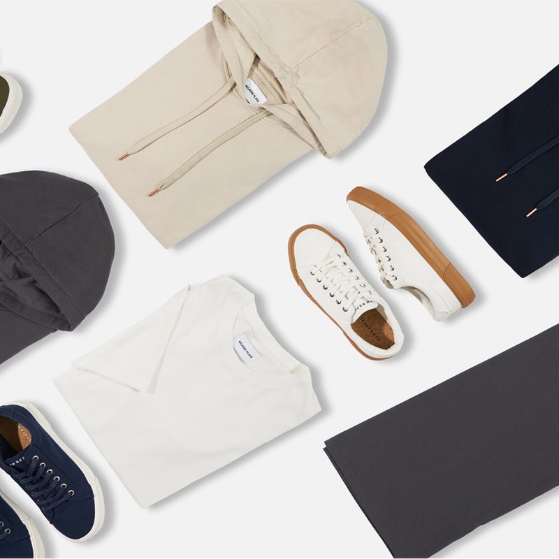 Articles of clothing lined up on white background.