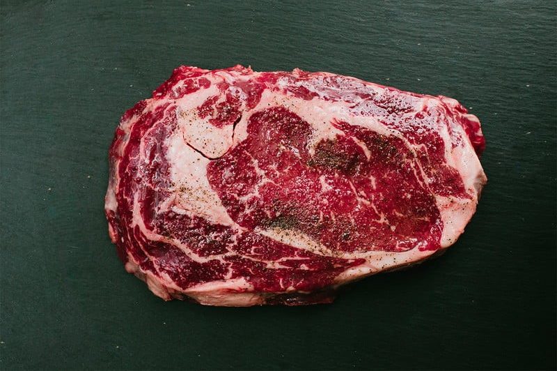 A raw ribeye steak.
