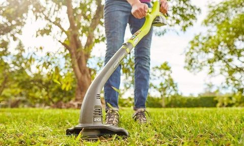 Using a Ryobi String Trimmer on a lawn.