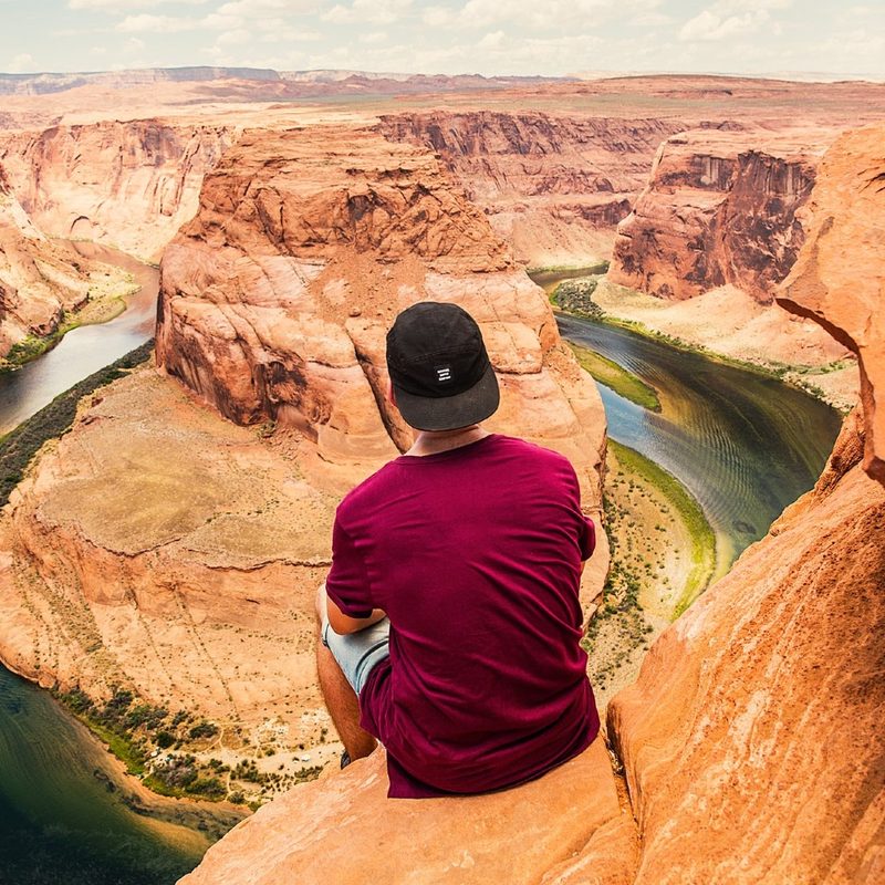 Man sitting on the rock overlooking Horsehoe Bend