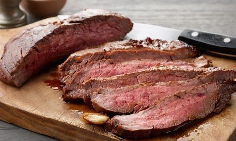 Soy-marinated flank steaks on a wooden chopping board from the Food Network