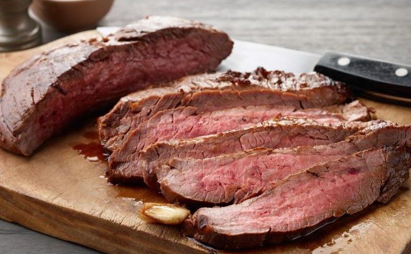 Soy-marinated flank steaks on a wooden chopping board from the Food Network