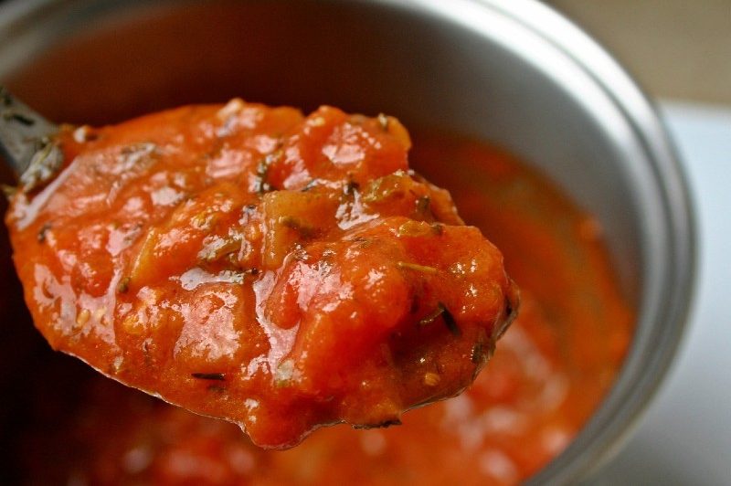 Spoonful of tomato sauce and herbs.