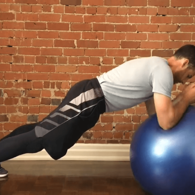 A man performing the stability ball alphabets.