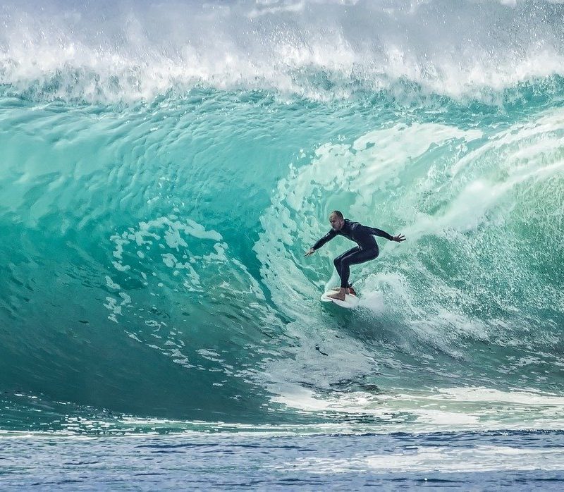 surfer in wet suit riding a wave.