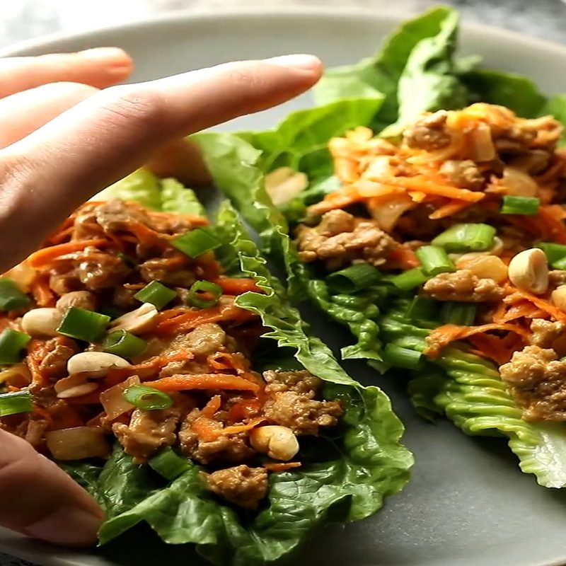 A hand holding a Thai turkey lettuce wrap.