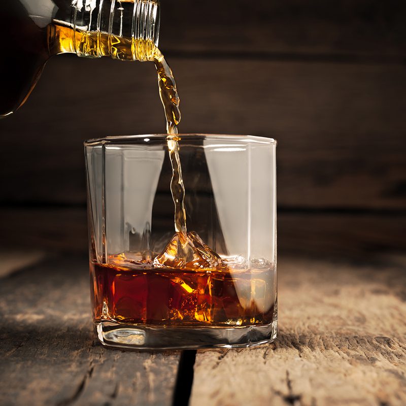 Pouring a glass of whiskey.