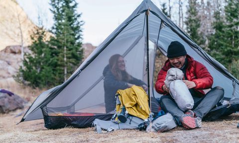 A man and a woman camping on a Gossamer Gear The Two tent.