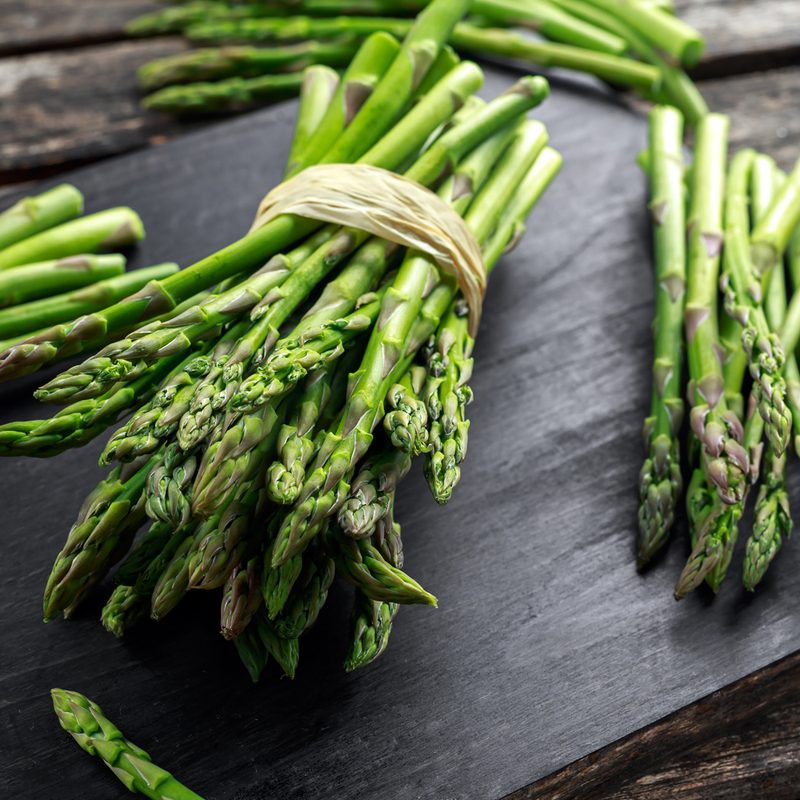 Asparagus stalks on cutting board.
