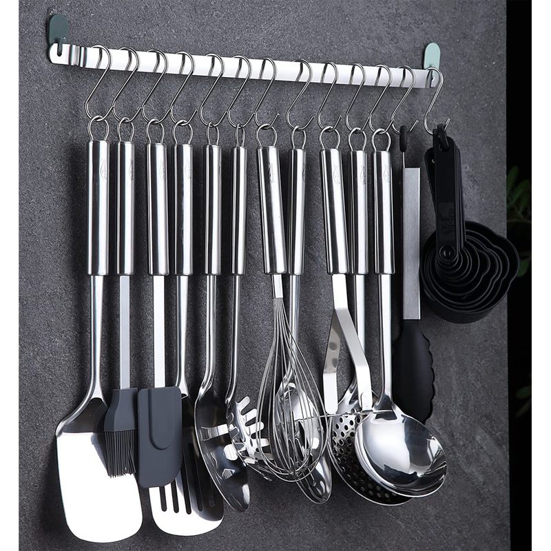 Kitchen utensils hanging on a stainless steel pegboard.