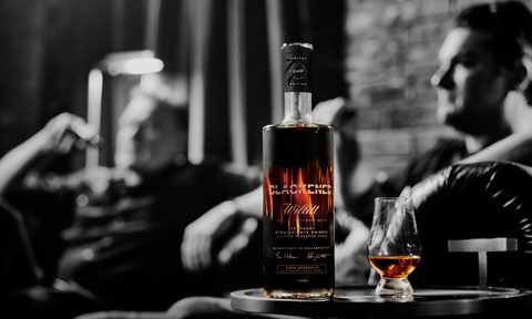 Blackened's Rob Dietrich (left) and Willett Distillery's Drew Kulsveen relax behind a bottle of the pair's new rye whiskey.